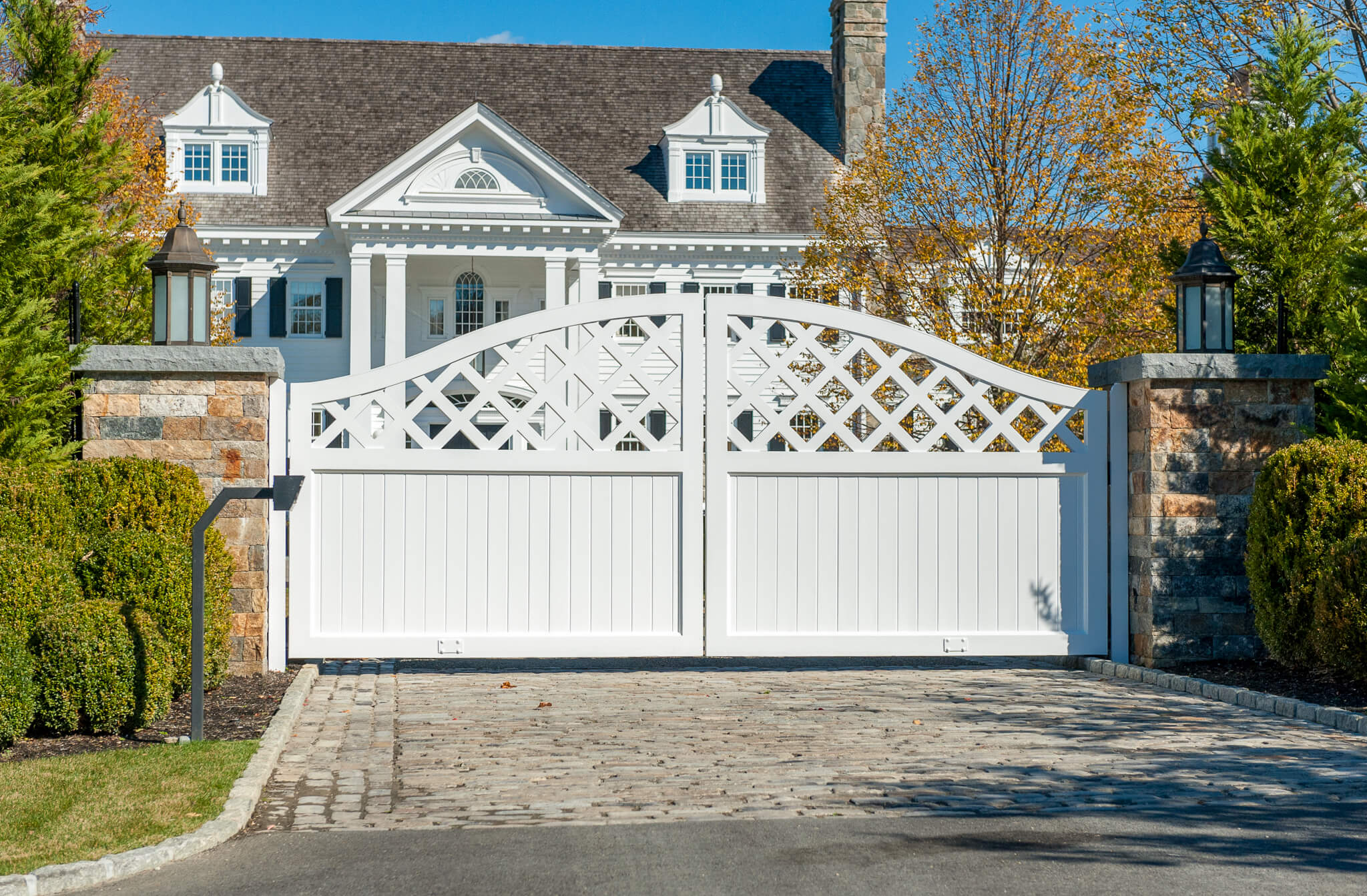 White composite driveway gate in front of a house